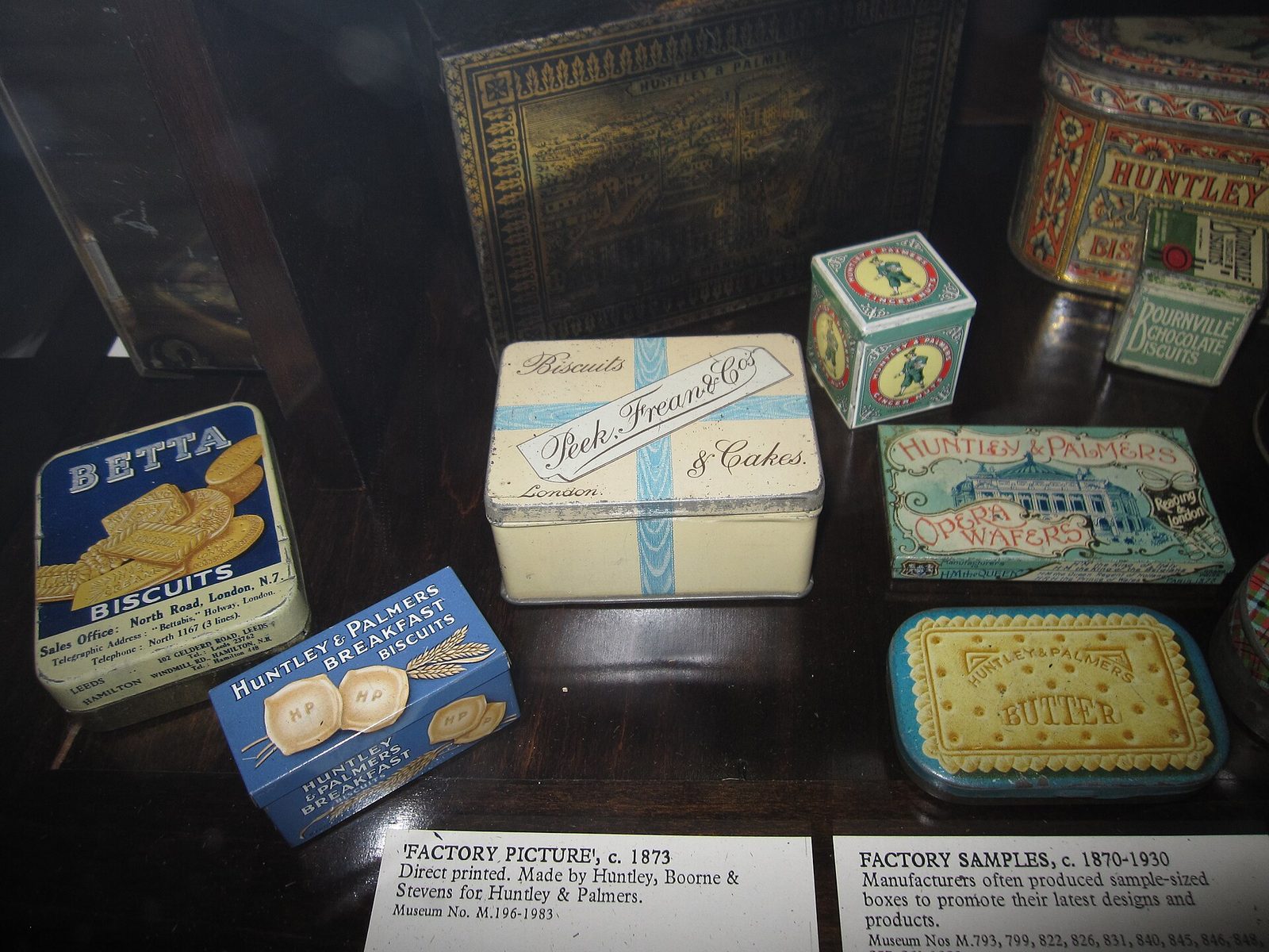 A museum display of decorated biscuit tins, circa 1870–1930
